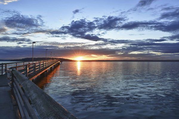 Muelle de madera en el mar, con puesta de sol ¿Cómo es dios?