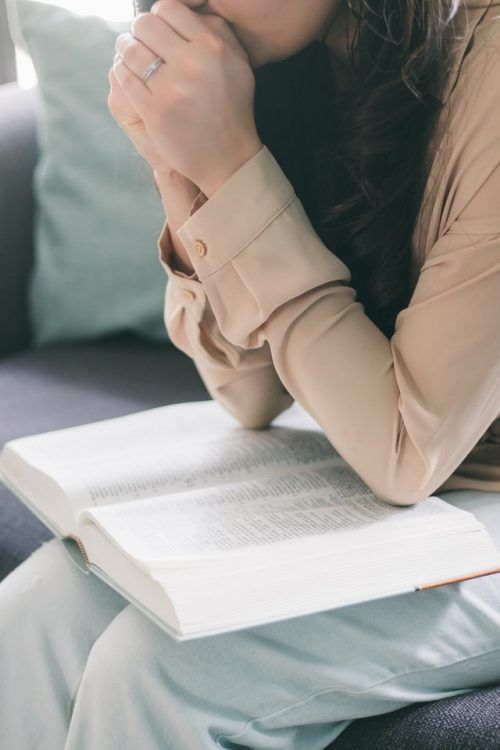 Mujer orando con la biblia